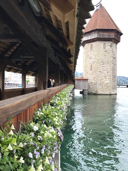 Wooden bridge and watch tower over water.