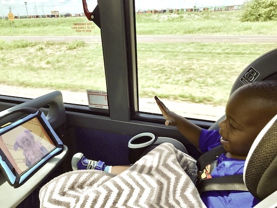 a young toddler in a car-seat watching a movie