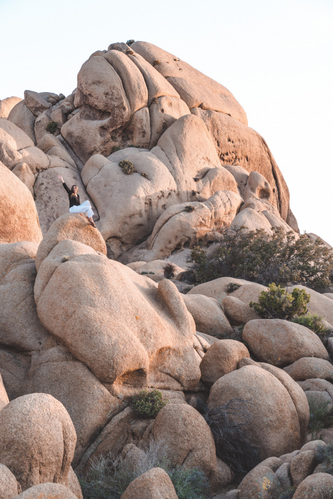 Girl sitting on the Jumbo Rocks at Joshua Tree National Park during sunset.