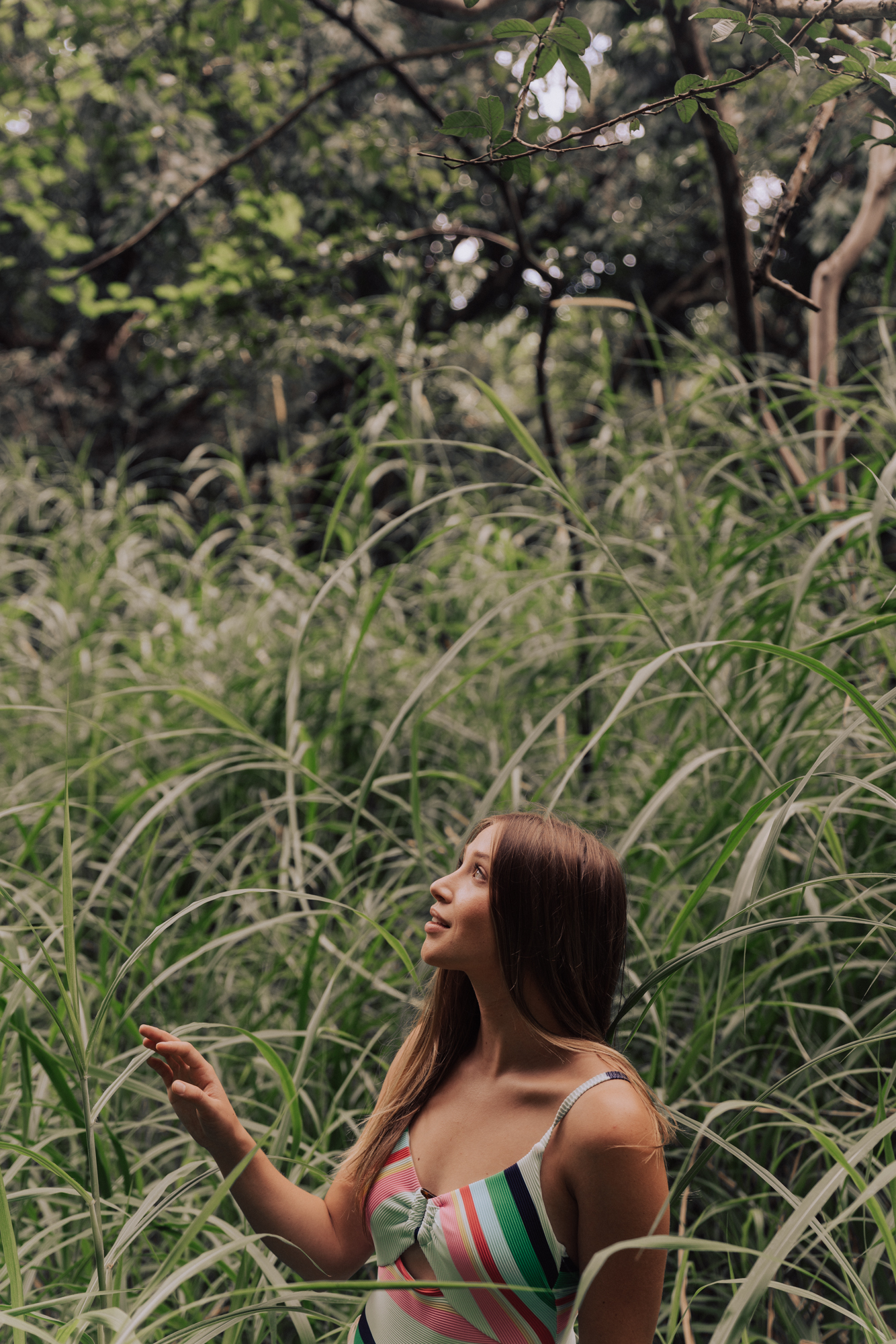 woman standing among lush and long, green grass. 