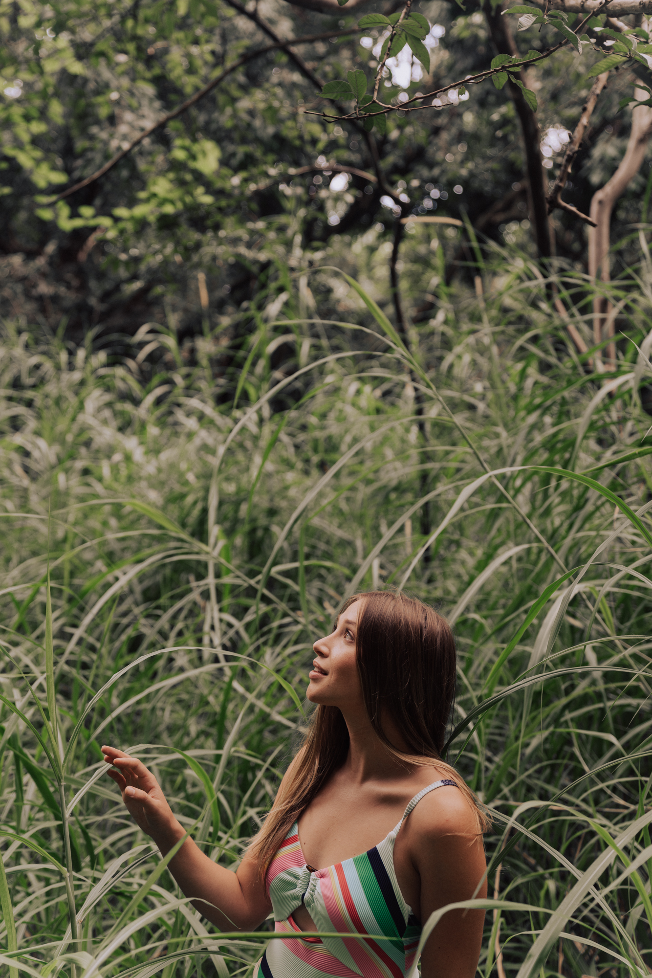 woman standing among lush and long, green grass.
