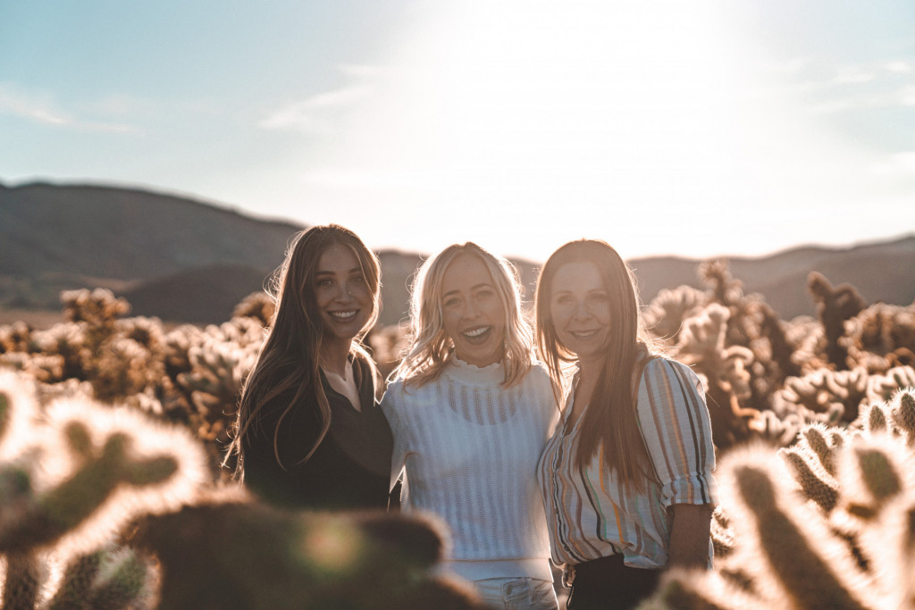 three women standing among the cacti in Joshua Tree national park