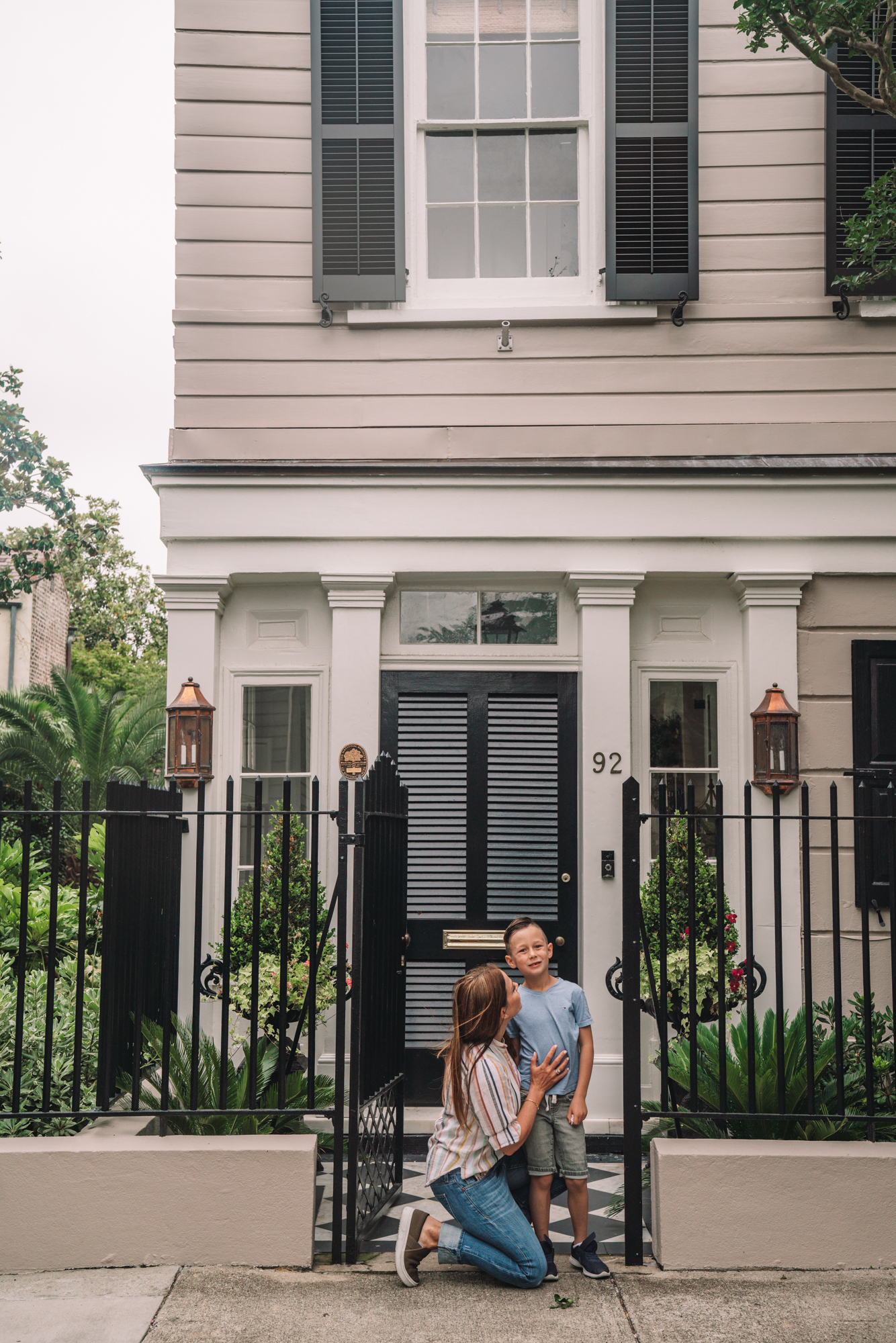 charleston sc visitors guide - a little boy and his grandma smile in front of a grand southern home. 