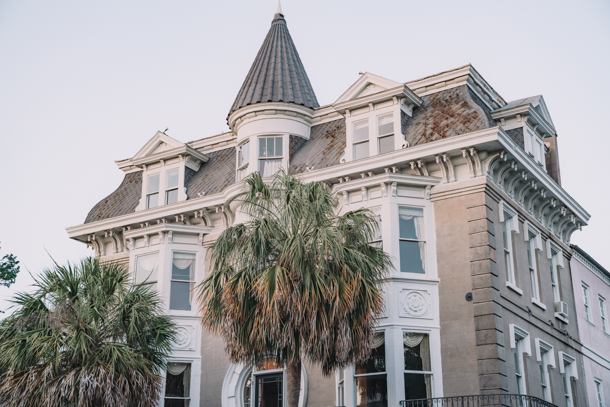 charleston sc visitors guide - a giant antebellum house with palmetto trees in front. 