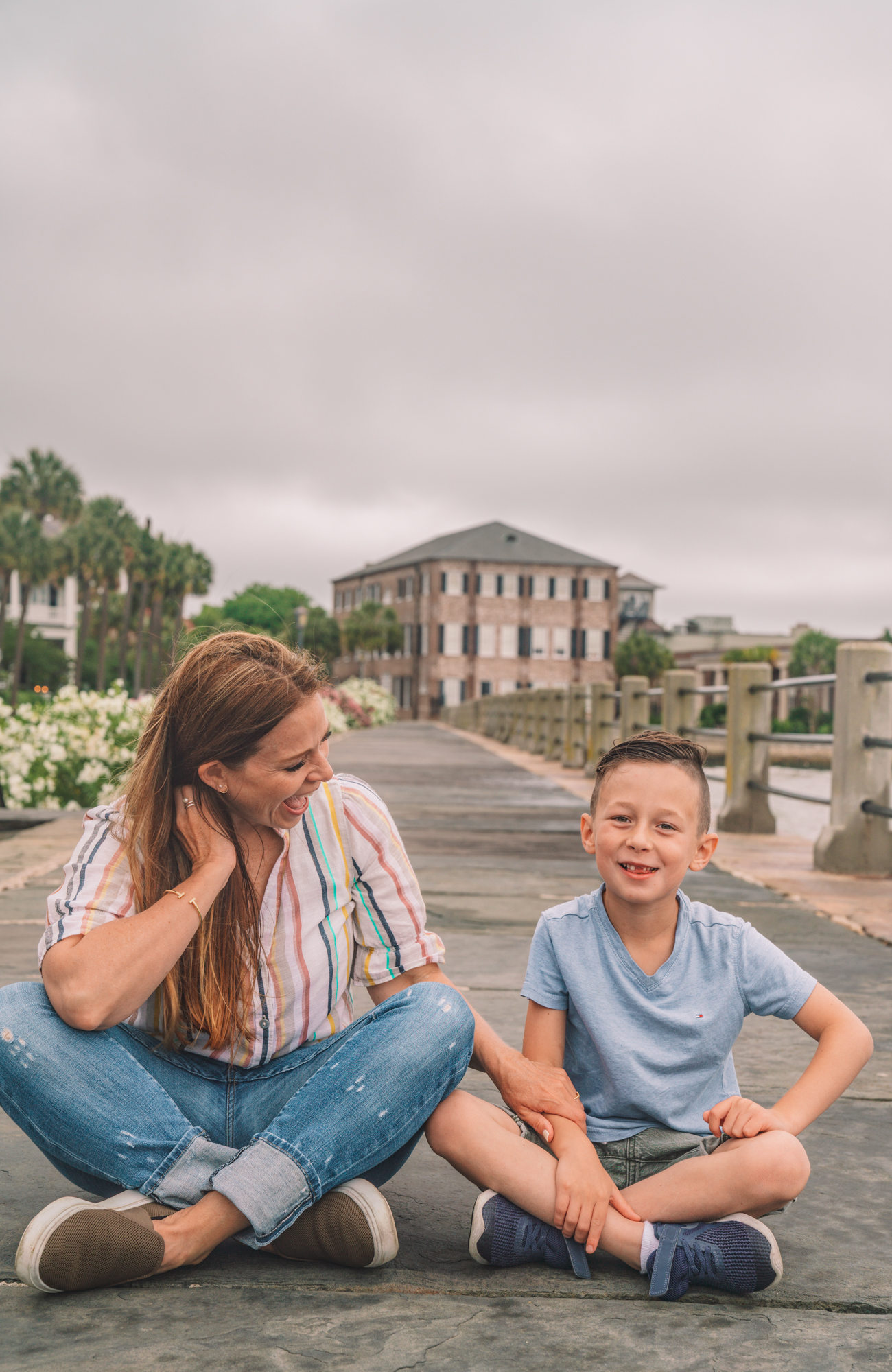 Things to do in Charleston sc with kids - a young boy and his grandma play on the sidewalk with antebellum style houses in the background. 