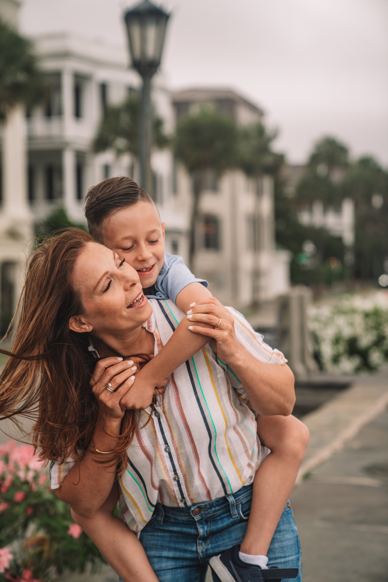 Things to do in Charleston sc with kids - a young boy and his grandma play on the sidewalk with antebellum style houses in the background. 