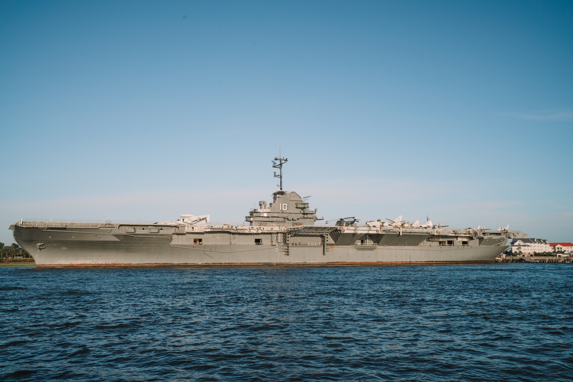 A gray naval ship sits on the water