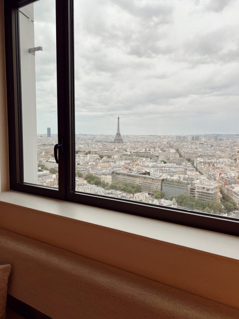 Eiffel Tower and Paris rooftops framed by a guest-room window at the Hyatt Regency Paris Étoile
