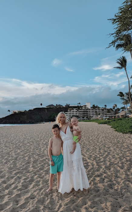 Kam with two sons on Hawaiian beach with palm trees and resort in background