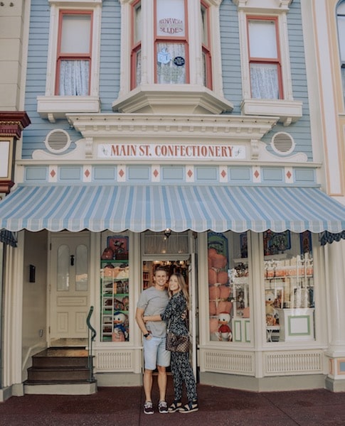 a young couple embracing on main street in disney world