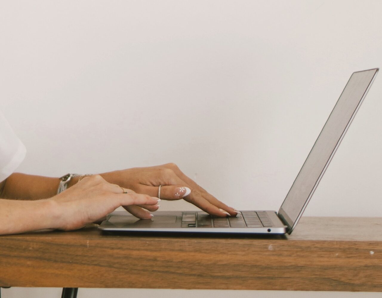 Close-up of a travel expert's hands while working on a laptop, emphasizing personalized coaching and strategic planning.