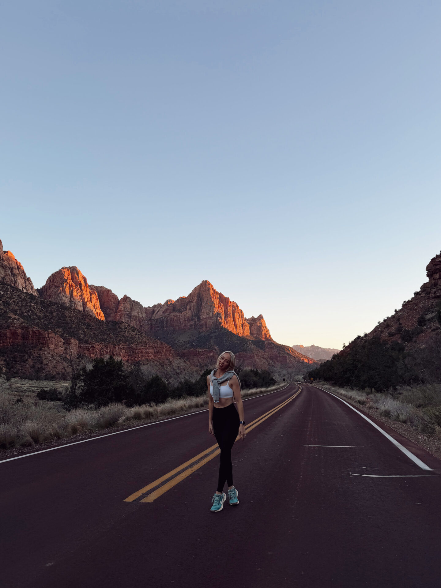 Woman on the road with the sunset from the Canyon Overlook Trail with panoramic views of Zion Canyon