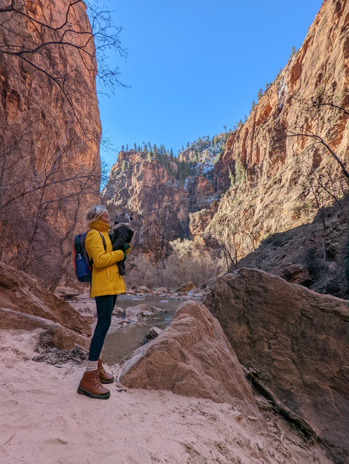 Mom and baby walking along the Virgin River toward the start of the Narrows hike in Zion National Park