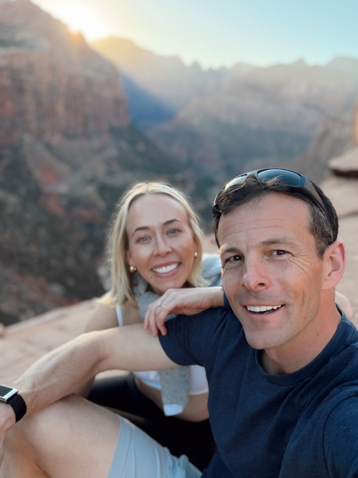 Couple watching the sunset from the Canyon Overlook Trail with panoramic views of Zion Canyon below