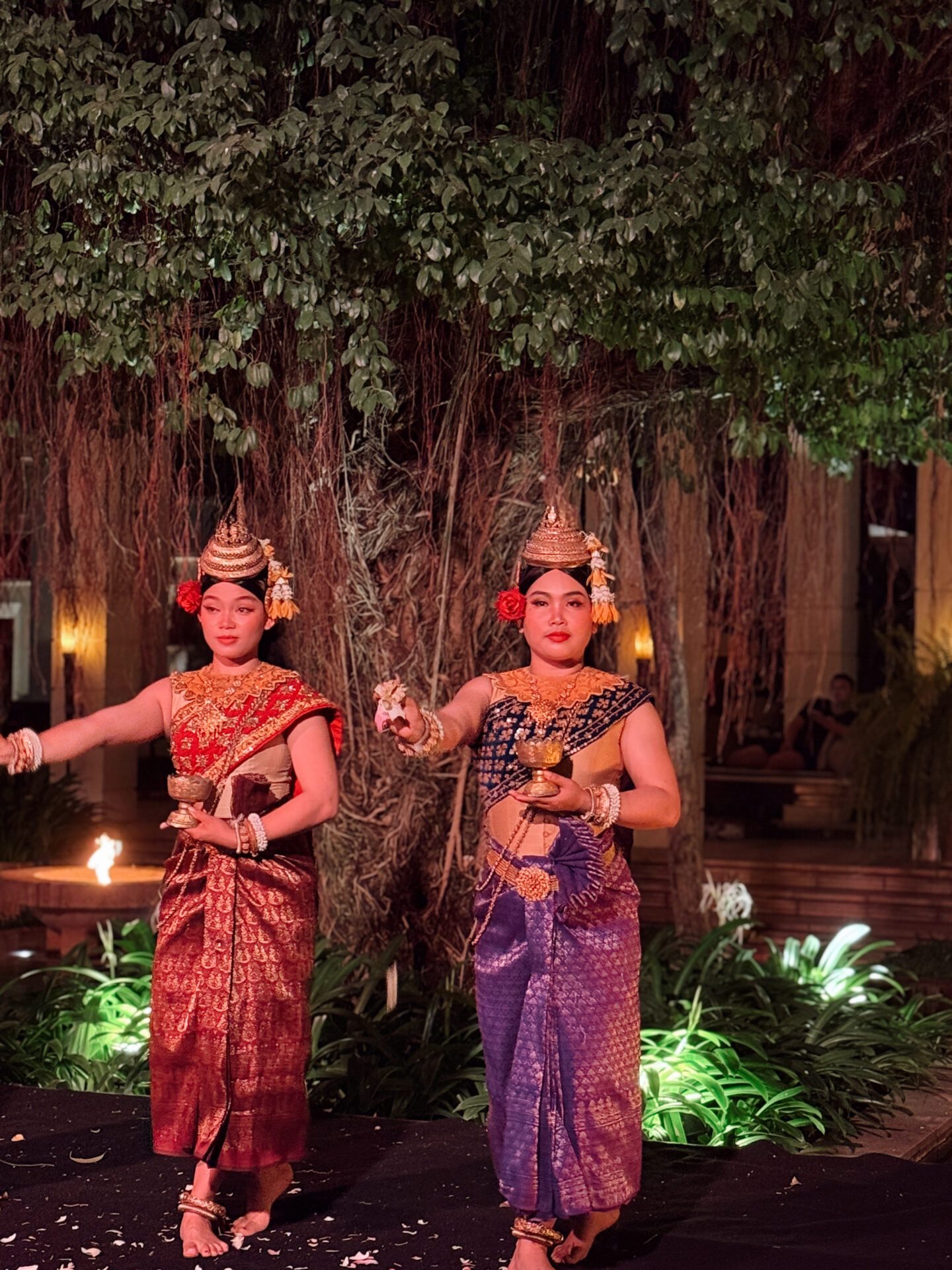 Two traditional Apsara dancers in colorful Cambodian silk costumes performing at the nightly Park Hyatt Siem Reap show