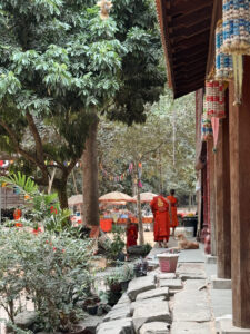 Buddhist monks in orange robes walking through temple grounds in Siem Reap