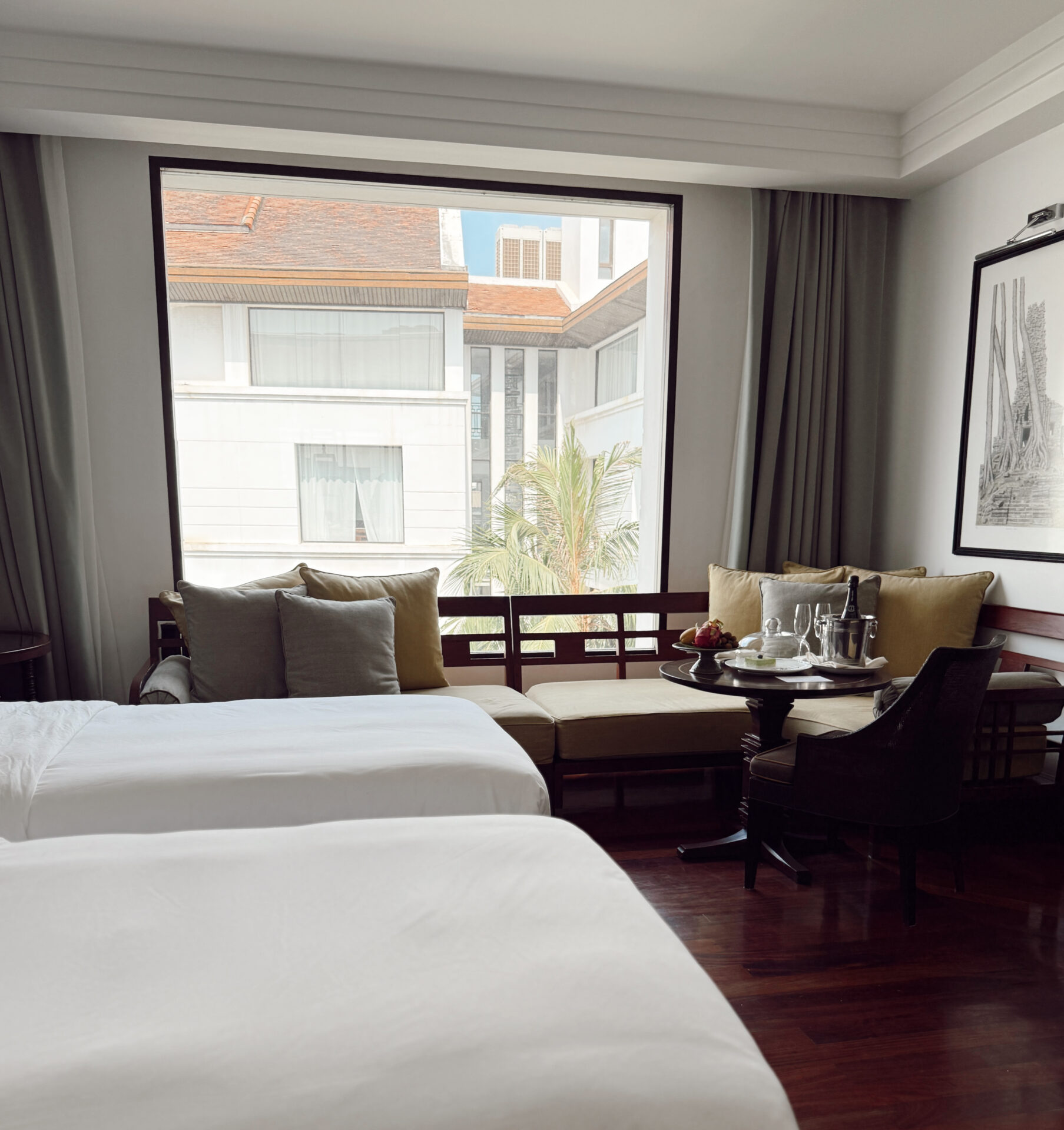 Park Hyatt Siem Reap renovated twin room with wooden floors, window seat, and welcome fruit platter