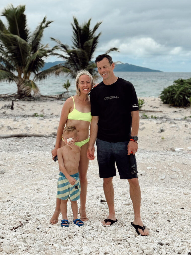 Family of three on a coral beach in Fiji, a favorite spot for where to go in Fiji with kids