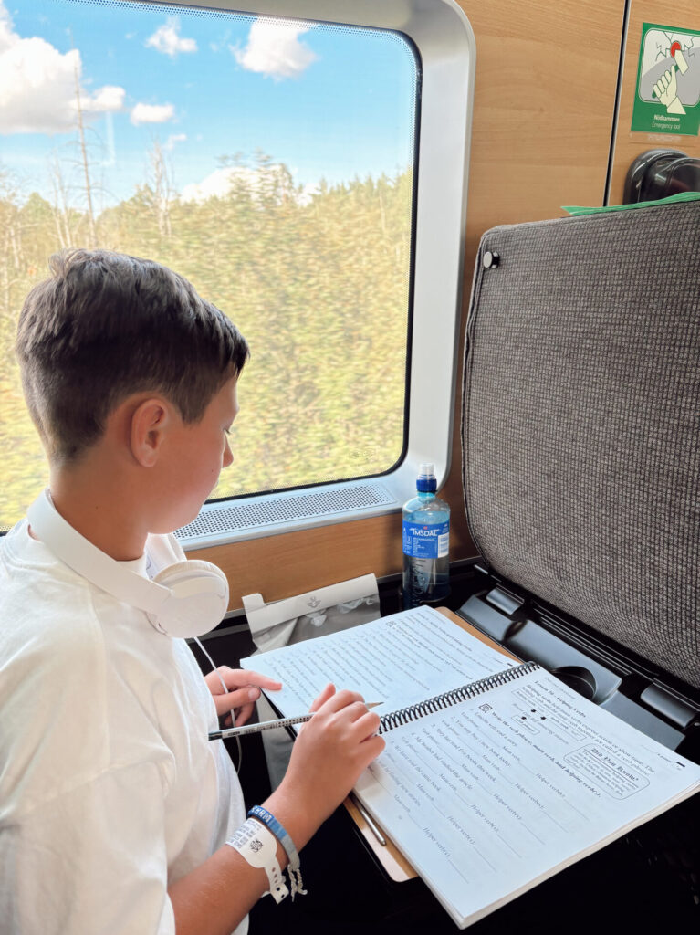 Student working on an independent study contract assignment on a train while traveling
